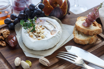 Camembert cheese with figs, honey and wine. Selective focus. Close view