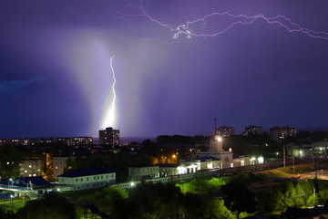 Lightning storm over city in purple light