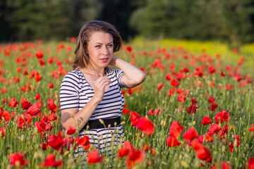 Smiling young woman on poppy field