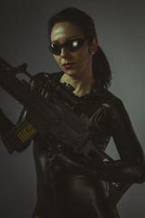 Naklejka premium Brunette woman with enormous bulletproof vest and gun