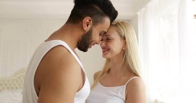 Couple love embrace smile standing face to face mix race man woman hug morning bedroom