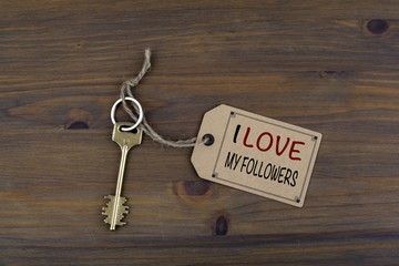 Key and a note on a wooden table with text: I Love My Followers