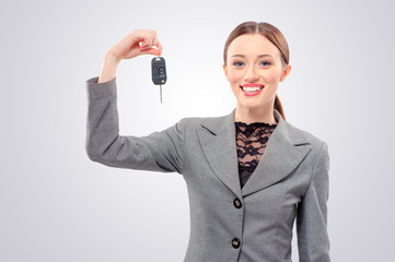 Ready to get on the road. Attractive young caucasian Woman with a car keys isolated on studio background.