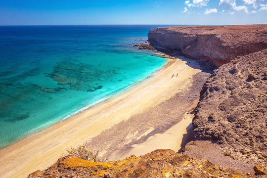 Sandy beach surrounded by cliff near Morro Jable, Jandia, Fuerteventura, Canary Islands, Spain.