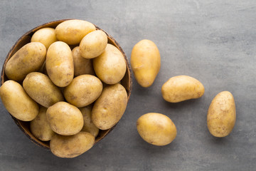New potato on the bowl, gray background.