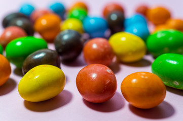 Close up of colorful round candy on pink background