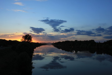 Wolken spiegeln sich im Wasser während des Sonnenuntergangs auf der Neuen Donau. Aufnahme vom 18. Juli 2016 bei Schleusenbrücke Wehr 2.