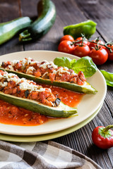Stuffed zucchini with pork, pepper, garlic, onion and cheese garnished with tomato salsa