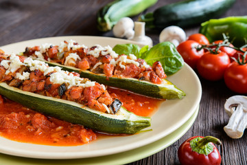 Stuffed zucchini with pork, pepper, garlic, onion and cheese garnished with tomato salsa