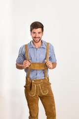 Junger Mann in Lederhosen lächelt