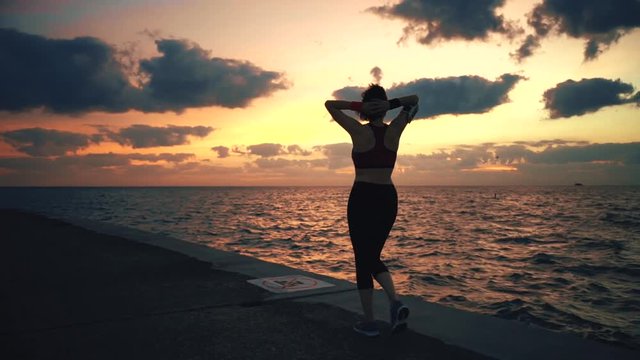 Runner athlete going at seaside and stops