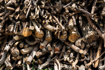 Background of dry chopped firewood logs stacked up on top of eac