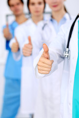 Group of doctors showing OK or approval sign with thumb up. High level and quality medical service,...