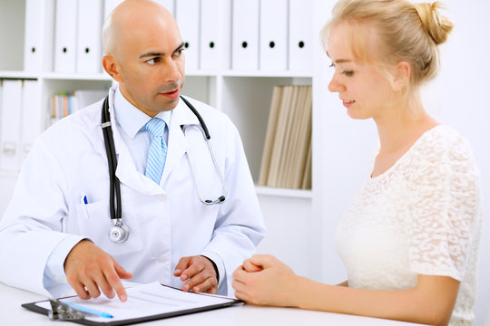 Confident Bald Doctor Man Consults His Female Patient