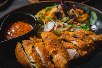 Fried Chicken with chili sauce and salad of radish, sprout, onio