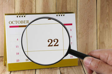 Magnifying glass in hand on calendar you can look Twenty-two dat