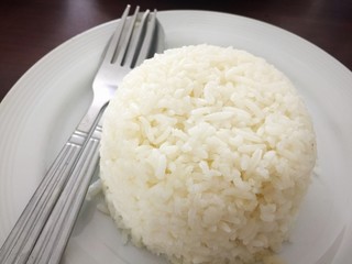 Rice on white dish on wooden background