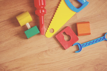Flat lay - toys tools on laminated wood floor.