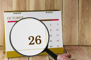 Magnifying glass in hand on calendar you can look Twenty-six dat