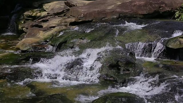 Whitewater flowing over rocks in small river in thailand