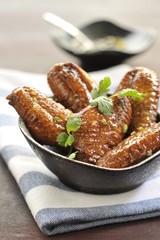 Fried chicken wings on black bowl in restaurant