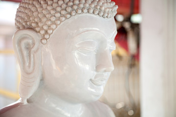 Beautiful white stone Buddha statue head. Buddhism sculpture calm, peaceful face