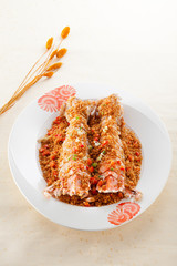 Salted deep fried Mantis prawns in Thai style on white plate