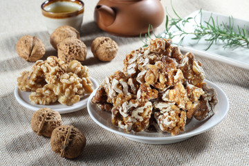 Candy of walnuts with tea in Chinese style on white plate