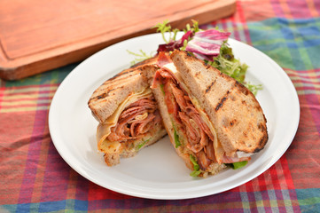 Sandwiches of bacon and herbs on white plate on the table