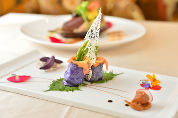 Wrapped asparagus with salmon on white plate in asian restaurant