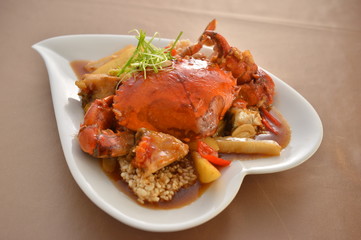 Fried crab in Singapore style on white plate in restaurant