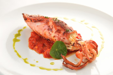 Fried squid with pennywort on white plate in restaurant