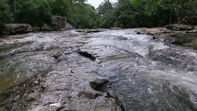 Whitewater flowing over rocks in small river in thailand