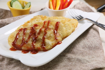 Crispy potato cake with chili sauce on white plate