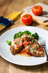 Fried loin of fish with broccoli and tomato on white plate