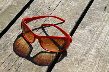 Red sunglasses on wooden background