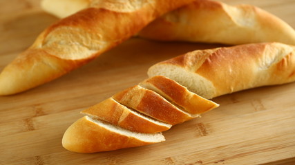 Chopped long bread on wooden cutting board