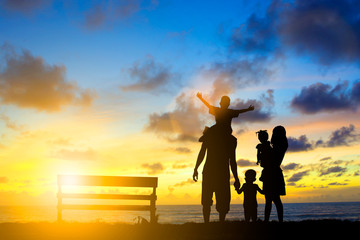 Silhouette family mother, father and young son holding hands, ta