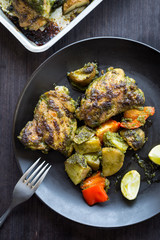 Roasted cilantro chilli chicken thighs and potatoes in black pan