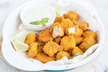 Tortilla crusted baked fish bites on white bowl