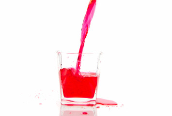 Pouring red sparkling wine in a glass  isolated on white background