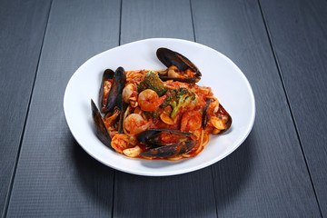 Seafood Tomato Pasta with shrimp and clams on white plate