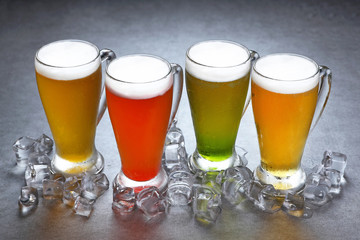 Colorful glass of beer with ice on grey background