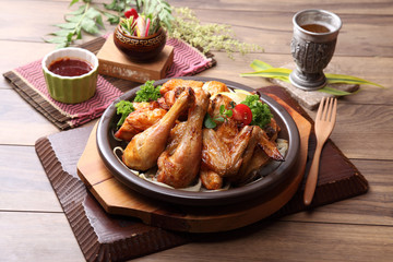 Fried chicken on black plate with lemon and herbs