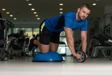 Personal Trainer Doing Exercise On Bosu Balance Ball