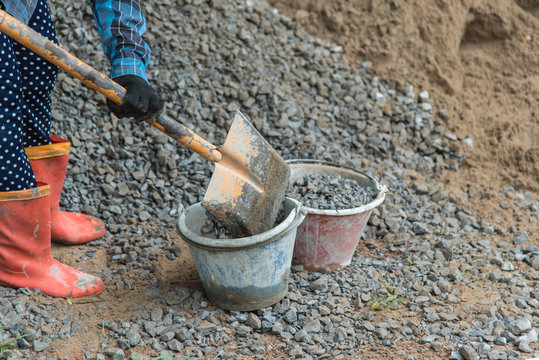 Shovel stuck in a pile of dirt,Construction worker is trying to move a kurb