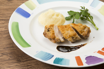Chicken saute balsamic source on white plate with herbs