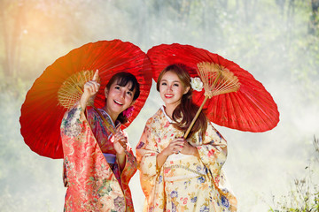 Two girls in kimonos acting are looking beautiful thing. - 120995470