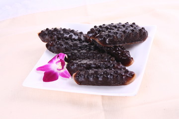 Fresh black sea cucumber on white plate