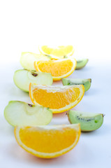 Fototapeta na wymiar Fruits orange, apple, kiwi, sliced on a white background.